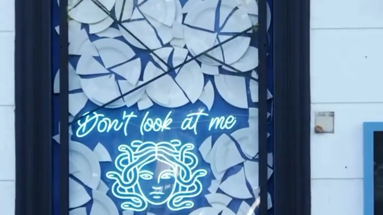 Neonbord 'Don't look at me' aan de ingang van MÉDUSA